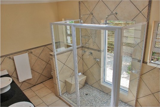 En-suite bathroom with a glass shower and tiled walls
