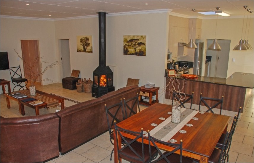 Open-plan living room with a fireplace, seating and dining table