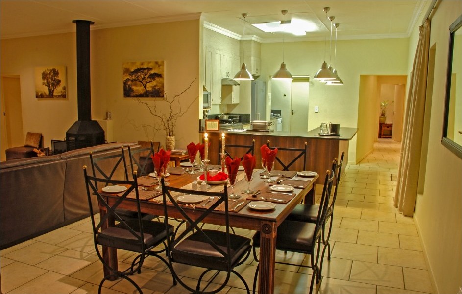 Dining table set with candles beside the fireplace and open kitchen