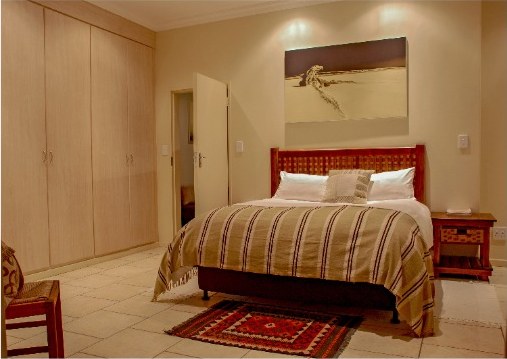 Master bedroom with a double bed, built-in cupboards and bedside tables