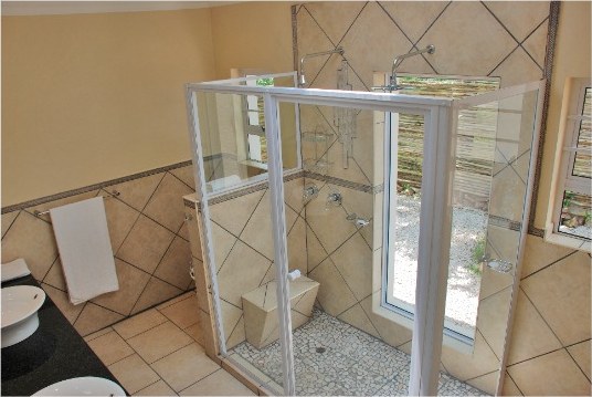 En-suite bathroom with a glass shower, toilet and tiled floor