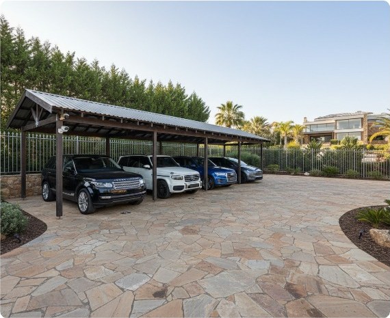 Covered parking area with vehicles on a paved surface