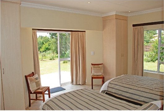 Second bedroom with twin beds and sliding doors opening to the garden